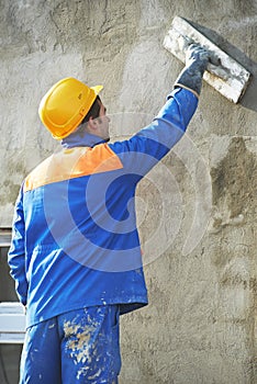 Worker at plastering facade work