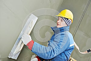 Worker at plastering facade work