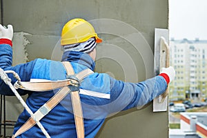 Worker at plastering facade work