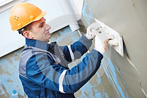 Worker at plastering facade work