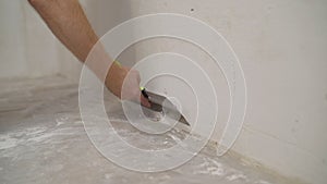 Work aligns with a spatula wall. Worker plastering a wall with a spatula