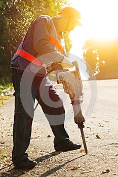 Worker with pneumatic hammer drill equipment