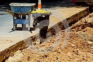 Worker with pneumatic hammer drill equipment breaking asphalt at road construction site