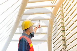 Worker is pointing his hand that holding old red walkie talkie d