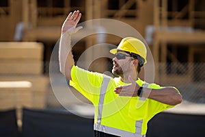 worker pointing out. Builder in a hard hat working on a construction project at a site. A builder worker in a helmet