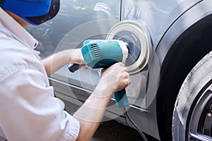 Worker polish a car with auto polisher photo