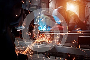 Worker polishes a metal surface with a grinder