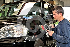 Worker polishing a car.