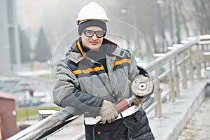 Worker polishing metal fence barrier