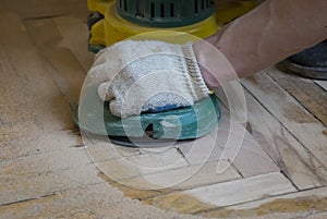 Worker polishing old wooden parquet floor