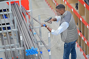 Worker with portable barcode scanner in warehouse