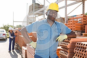 Worker posing near redbricks at a warehouse