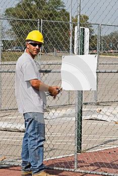 Worker Posting Blank Sign