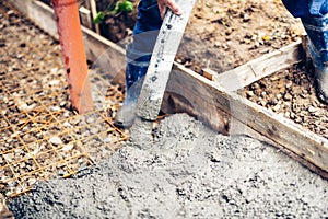 Worker pouring cement and concrete with pump tube on reinforcement steel bars