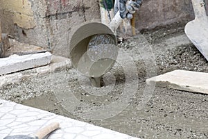 Worker pouring cement for pavement instlalation