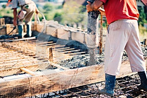 Worker pouring concrete or cement with automatic pump on construction site. Industrial details