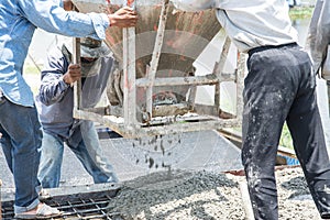 Worker pouring concrete works at construction site