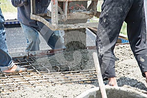 Worker pouring concrete works at construction site