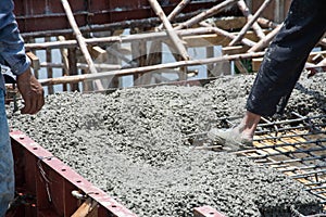 Worker pouring concrete works at construction site