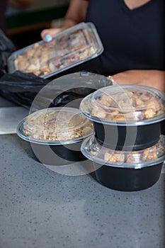 worker prepares food to go plastic containers