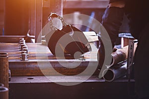 Worker prepares iron pipes for welding