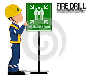 A worker is presenting the fire assembly point sign
