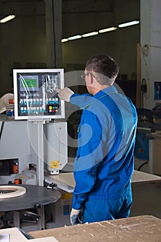 The worker presses buttons of the pane