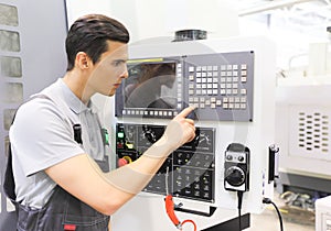 Worker pressing buttons on CNC machine