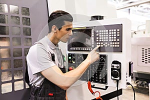 Worker pressing buttons on CNC machine