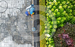 Worker with Pressure Washer Washing Residential Driveway Aerial View