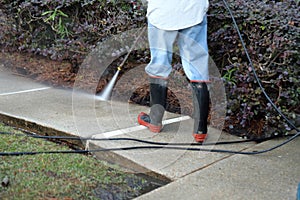 Worker pressure washing sidewalk