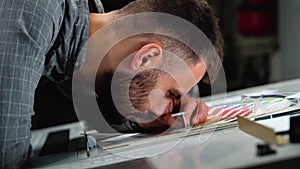 Worker in a printing press factory uses a magnifying glass and check the print quality