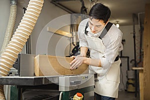 Worker processes board on woodworking machine