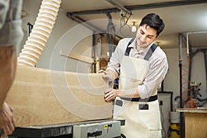 Worker processes board on woodworking machine