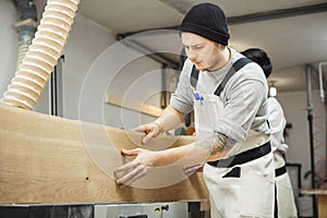 Worker processes board on woodworking machine