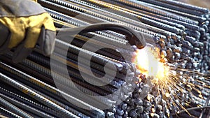 Worker processes metal pins with welding machine closeup
