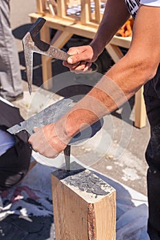 Worker produces roofing slate using a slate hammer. photo