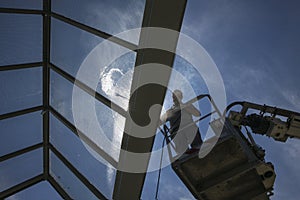 Worker of Professional Facade Cleaning Services washing a glass