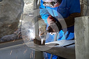 Worker with protective mask and gloves grinding/we