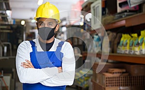 Worker in protective mask taking inventory in building materials store