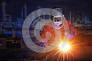 Worker with protective mask welding metal and sparks