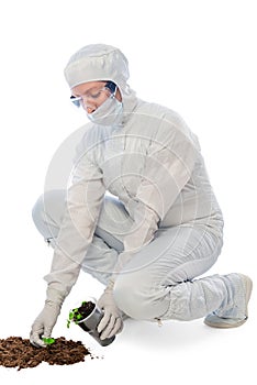 Worker in a protective suit examines the ground