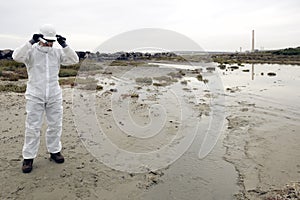 Worker in a protective suit examining pollution