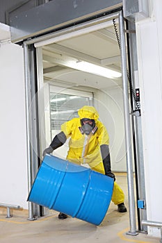 Worker in protective uniform rolling barrel