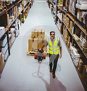 Worker pulling trolley with boxes