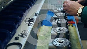 Worker punching holes in metal unit. Factory workman working with metal billets