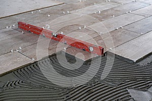 The worker puts ceramic tiles on the construction site