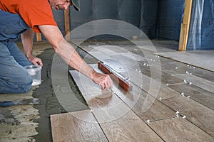 The worker puts ceramic tiles on the construction site