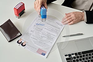 Worker putting approved stamp on visa application