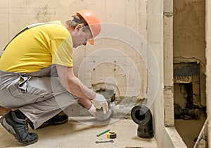 The worker is putting a sewage drain pipe